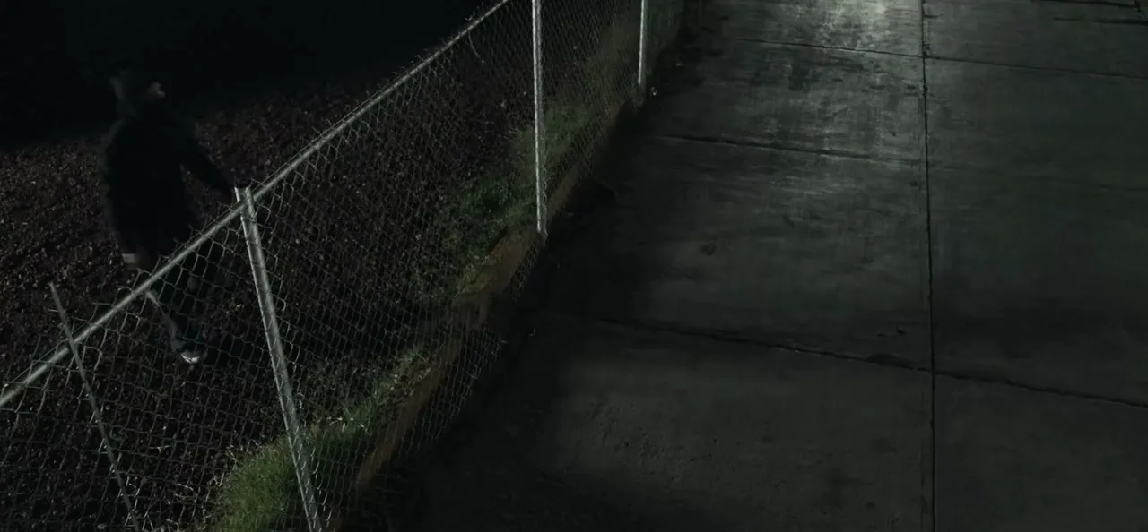A fence line at night, an intruder lit by a Verkada spotlight, and the siren and strobe devices